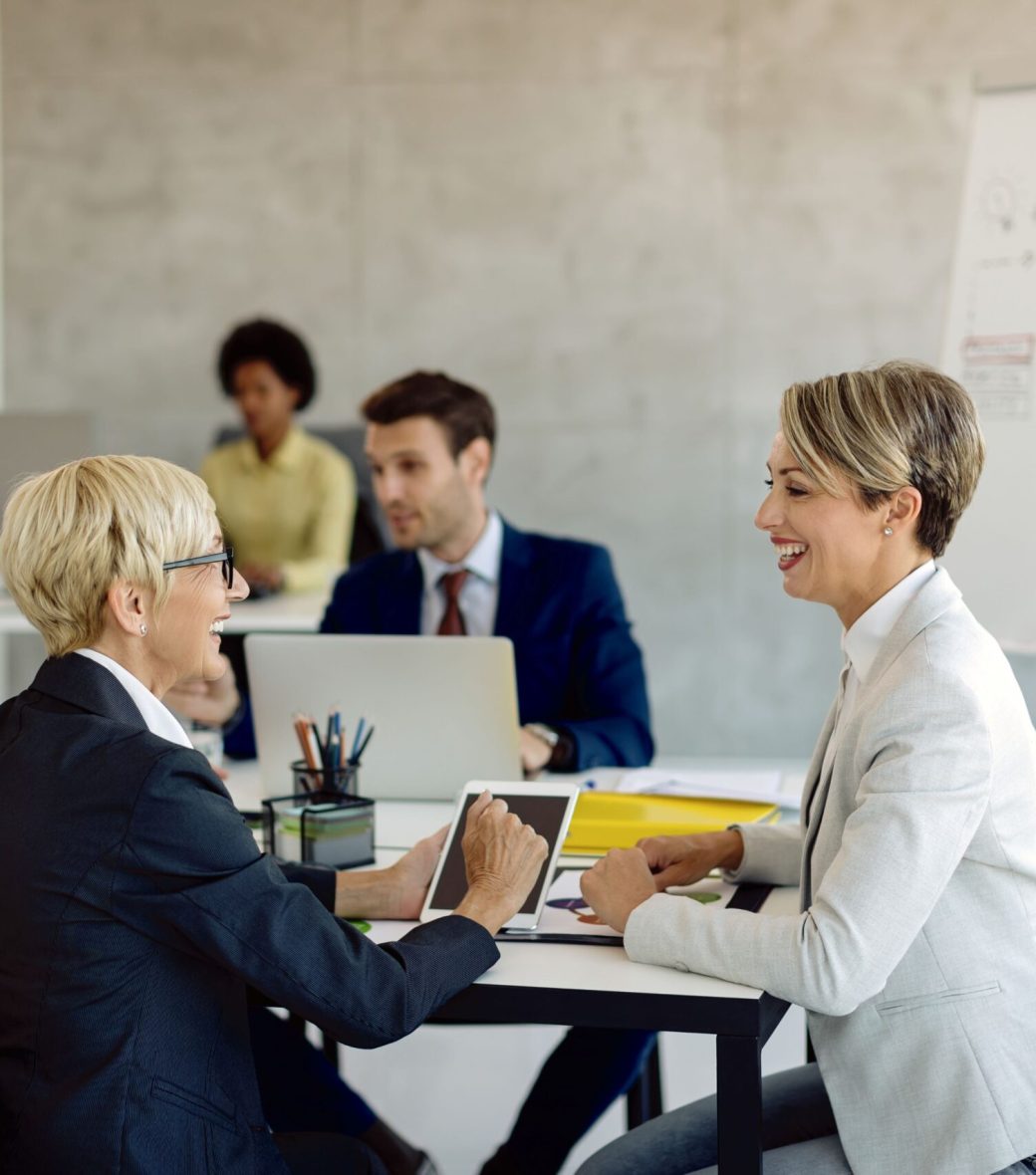happy-female-colleagues-talking-business-meeting-office happy-female-colleagues-talking-business-meeting-office